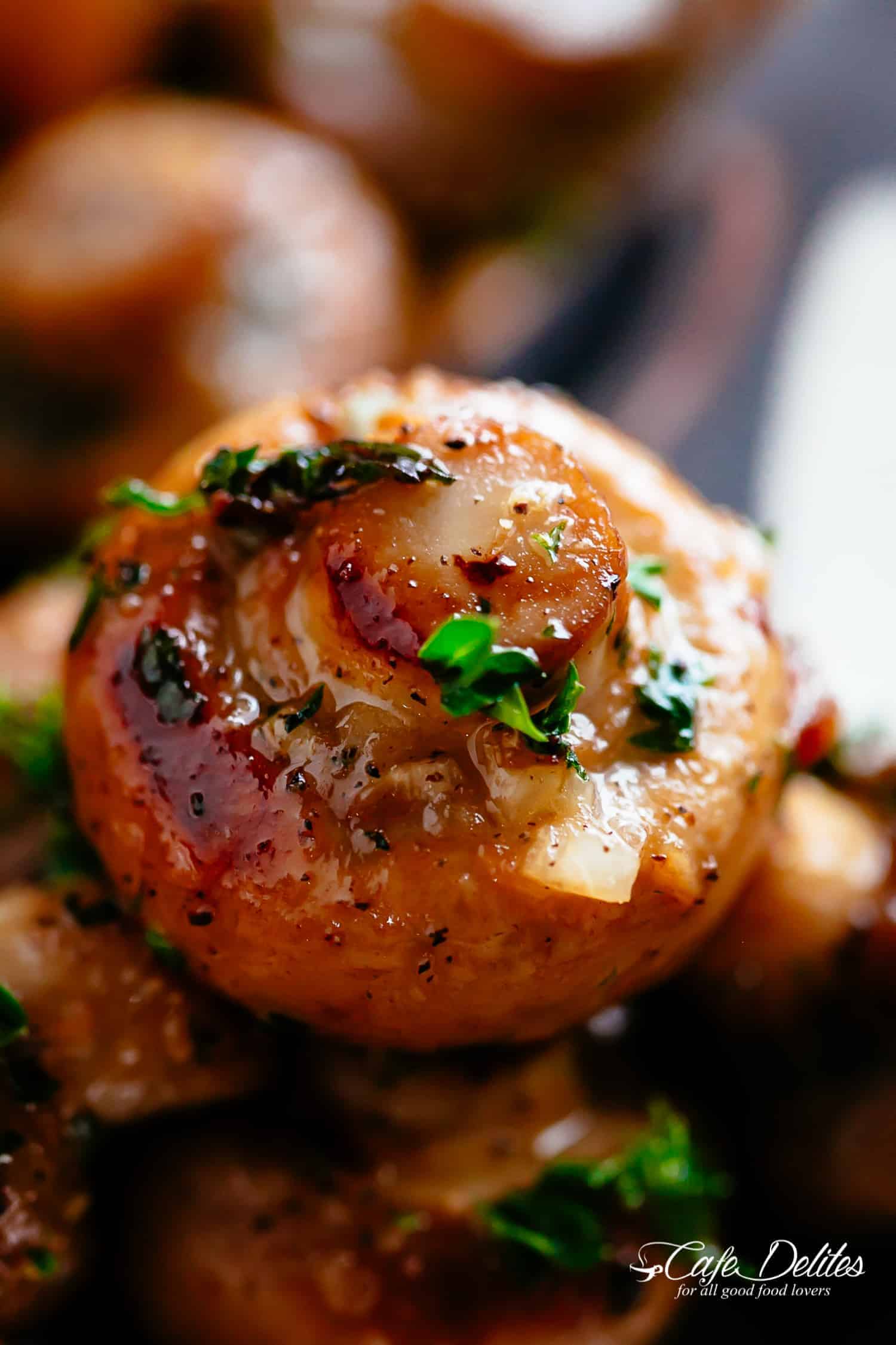 Close-Up image of garlic mushrooms in buttery garlic sauce.